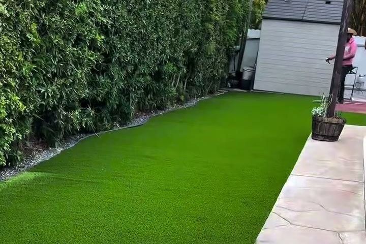 La misma franja con grama artificial pareja, del seto al pavimento de la piscina.
